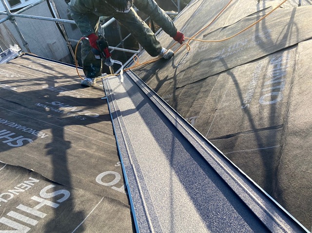 屋根の谷部分に板金を設置している様子