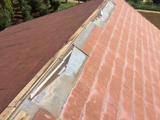 頂上付近のスレートが割れ棟板金も飛散しています