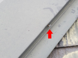 棟板金の固定用の釘が浮いている