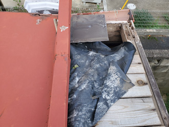 金属屋根が剥がれて防水紙がむき出しになっている