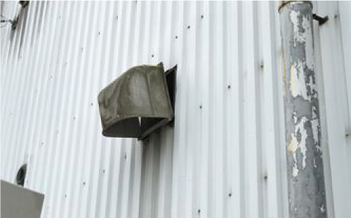 室外の外壁に施工されている換気扇が外れかけています