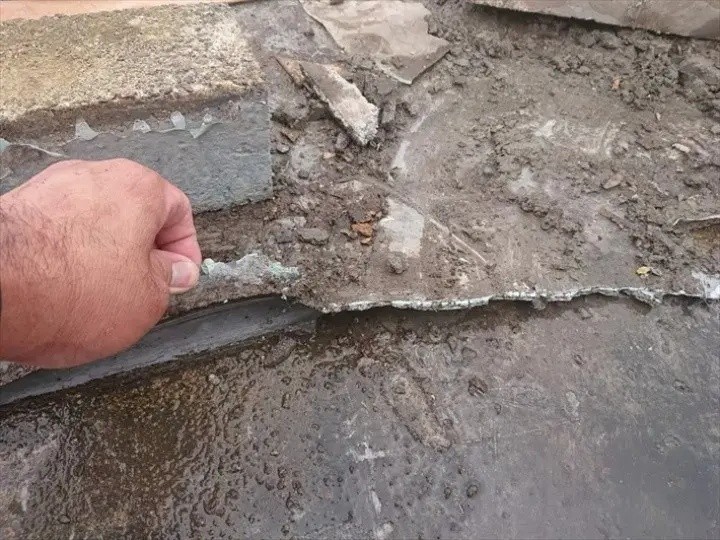 上から重ねて施工された防水層は物置下で途切れている状態