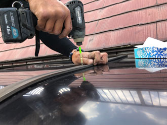 フレームの両サイドをビスで固定して取り付けている平板