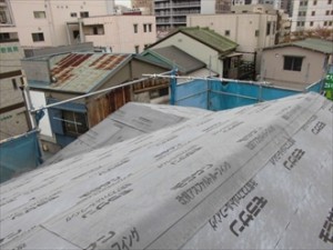屋根の形状に合わせてカットしながら防水紙を敷設