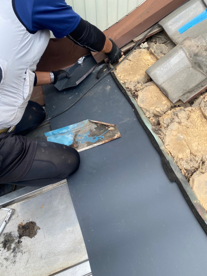 北区で屋根板金と壁のつなぎ目の加工をしている様子