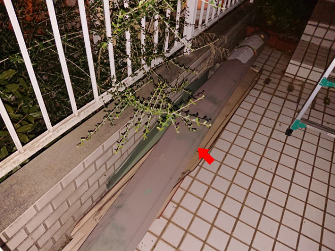 外れた棟板金が地面に落ちている