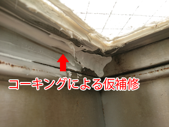 天窓の雨漏りをコーキングで仮補修している