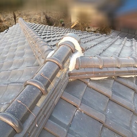 鬼瓦の周りと隅棟の端を漆喰で固めます