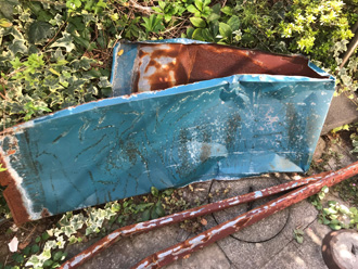 庭に剥がれた屋根材がある