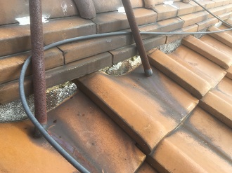 アンテナの錆で汚れた瓦と剥がれかけた漆喰