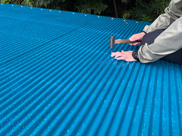 新しい青いトタン屋根を施工中の様子