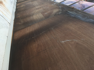 金属屋根が剥がれ木部がむき出しの庇