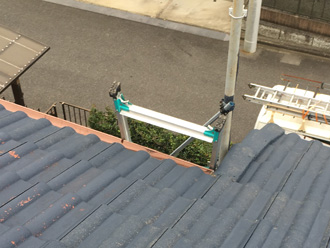 はしごを使って屋根の調査を行う