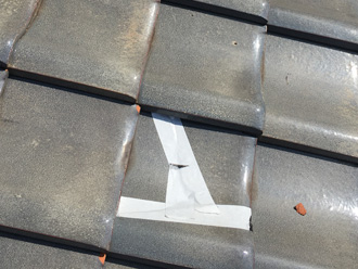 割れた瓦をテーピング補修している