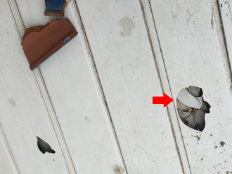 屋根から落下してベランダ床に穴が空いている