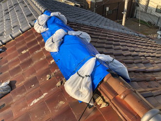 台風により瓦が飛散した釉薬瓦屋根のビニールシートによる応急処置（棟部分）