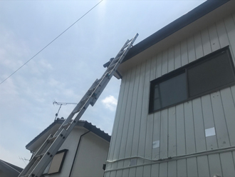 はしごで屋根に上って点検