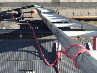 はしごで屋根に上って調査