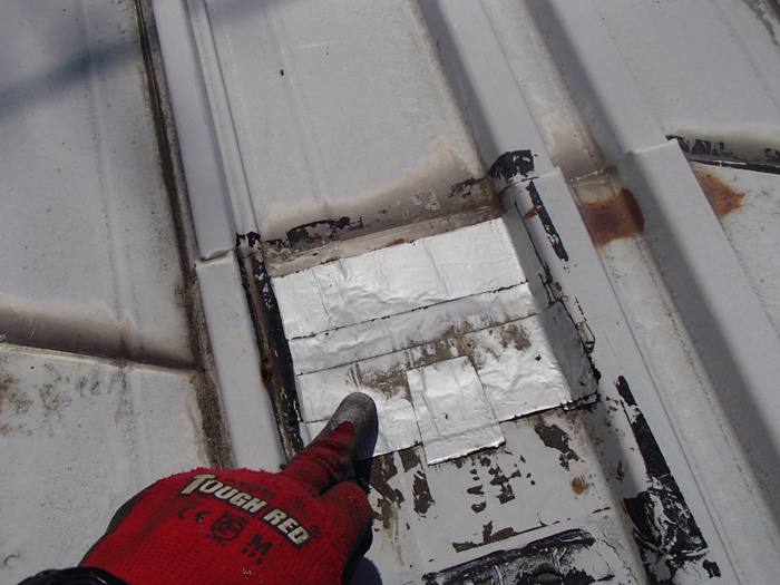 車庫での雨漏りを調査したところ屋根の補修箇所（ブチルテープ）が古くなっているのが見つかりました