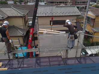 やねカバー工法　屋根材をクレーンで屋根に移動