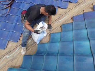 取り外した谷板金の周りを清掃する様子