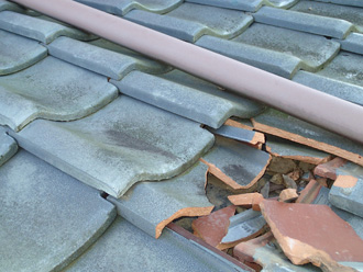 下屋に落下した瓦で下屋の瓦が割れている