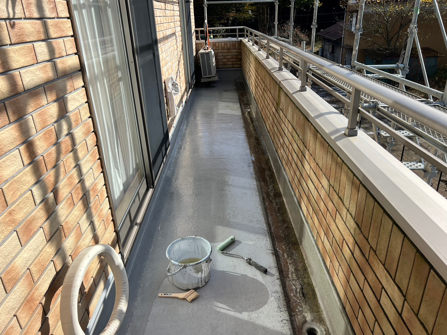 守山区のベランダに防水施工前のプライマーを塗布しています