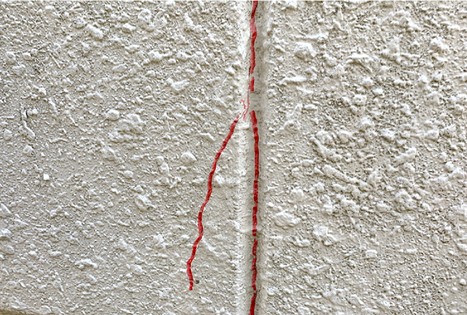 パネル同士の継ぎ目に出来たクラック部分に、赤いペンで印をつけます