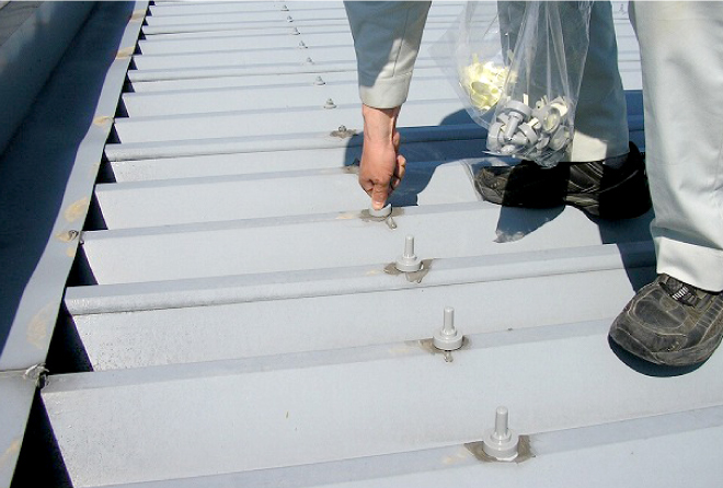 ボルトキャップを折板屋根に一個一個被せていきます