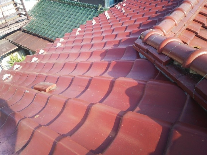 屋根上に瓦が落下している状況