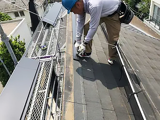 片流れ屋根の棟板金を新しく施工している様子