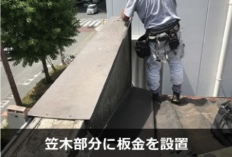 職人が笠木へ板金を取り付けている様子