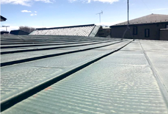 屋根材がたわんで波を打っています