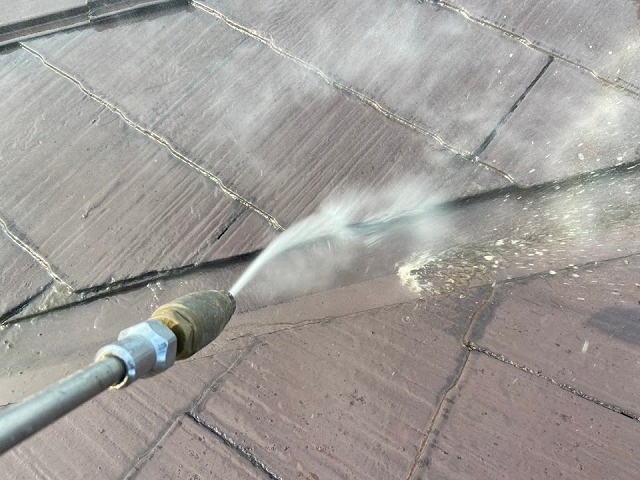 屋根についた鳥の糞を高圧洗浄で落としている様子