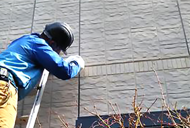 梯子を使って、外壁の古いシール材を撤去していきます