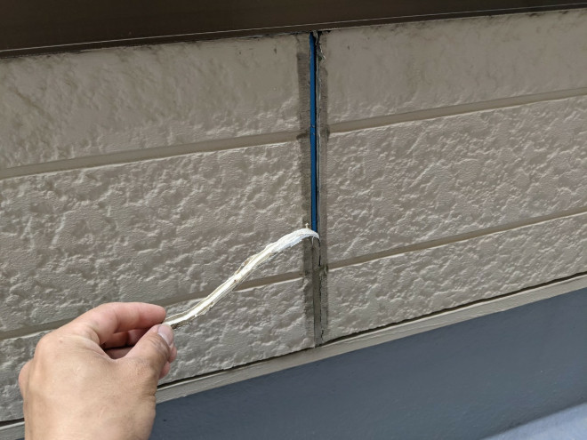 春日井市シーリング工事で古いシーリング材を剥がしている写真