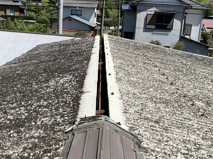 棟板金が外れ、建物の素地が剥き出しに